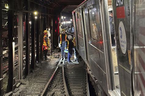 NYC subway crews wrestle derailed train back on tracks, as crash disrupts service for second day